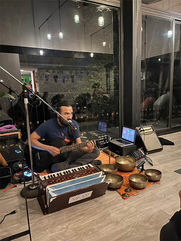 Músico con armonio y cuencos tibetanos en evento de kirtan en Centro Kanda CDMX