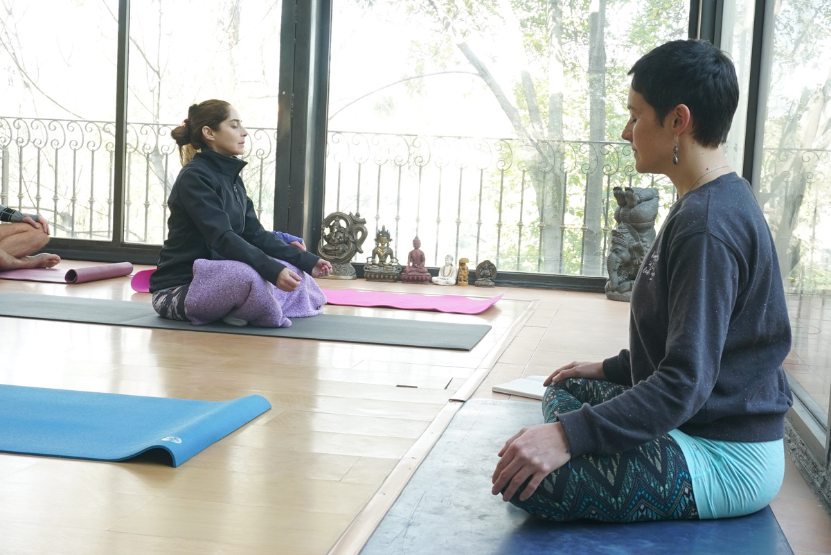 Alumnas en meditación sukhasana junto a estatuas en Centro Kanda CDMX